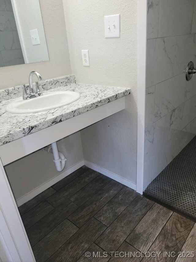 bathroom featuring a tile shower and vanity