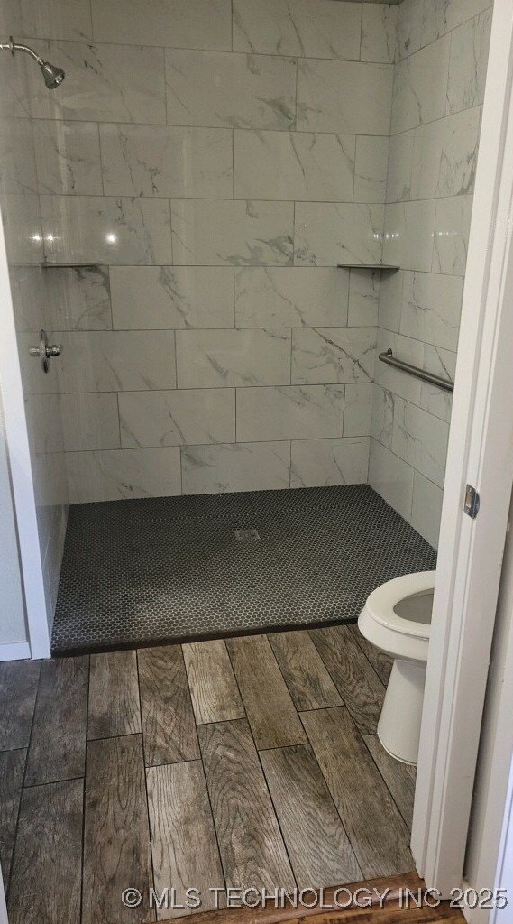 bathroom featuring toilet and tiled shower