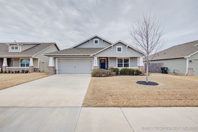 craftsman inspired home with covered porch, a garage, and a front yard