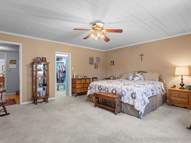 carpeted bedroom featuring wood ceiling, ceiling fan, crown molding, a spacious closet, and a closet