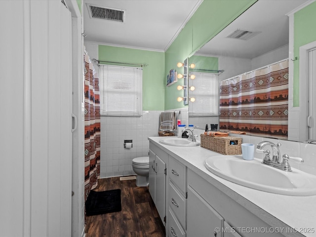 bathroom featuring vanity, crown molding, toilet, tile walls, and wood-type flooring