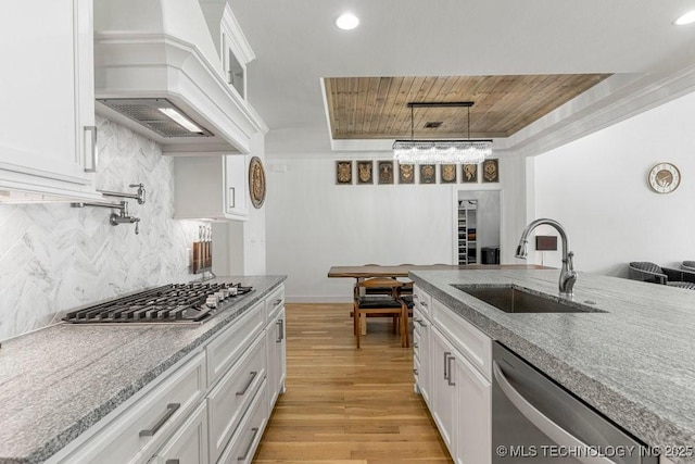 kitchen with sink, stainless steel appliances, white cabinetry, and custom exhaust hood