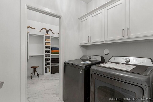 laundry area featuring separate washer and dryer and cabinets