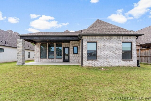 rear view of house featuring a patio area and a yard