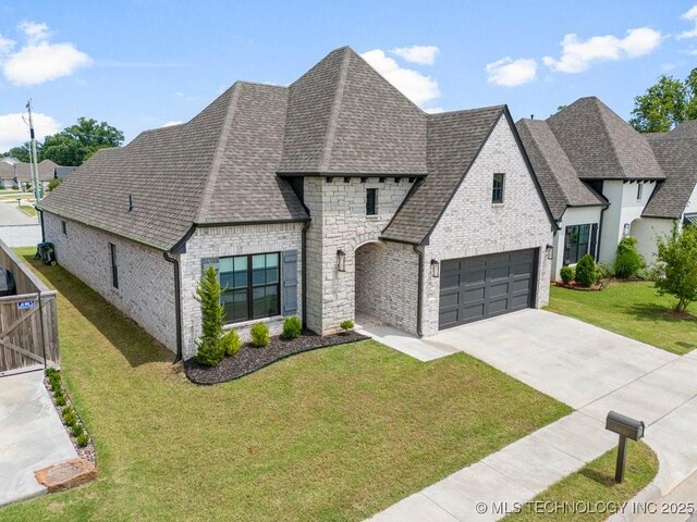 french country home with a front lawn and a garage