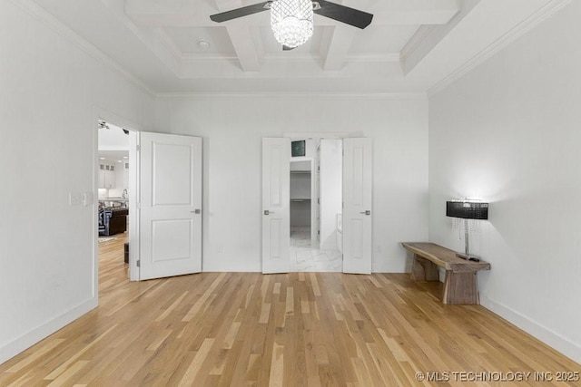 unfurnished bedroom with beam ceiling, ceiling fan, crown molding, a closet, and hardwood / wood-style flooring