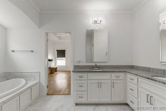 bathroom featuring vanity, ornamental molding, and a tub