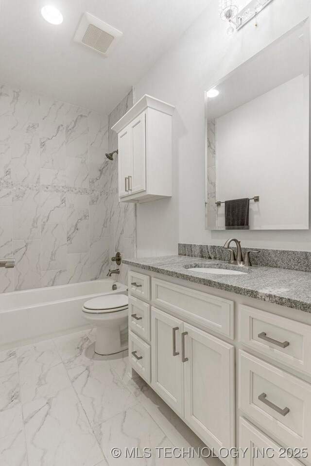 full bathroom featuring tiled shower / bath combo, toilet, and vanity