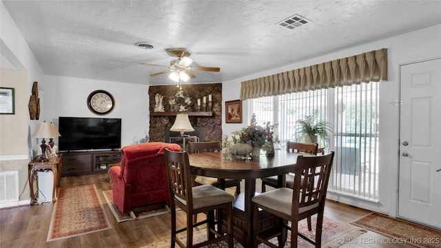 dining area with ceiling fan, dark hardwood / wood-style flooring, and a textured ceiling