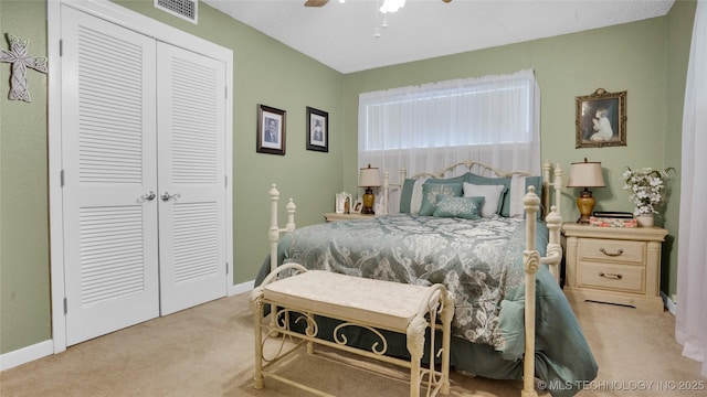 carpeted bedroom with a closet and ceiling fan