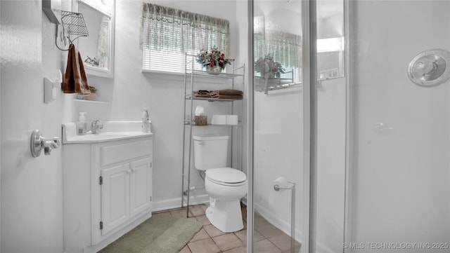 bathroom with tile patterned flooring, vanity, an enclosed shower, and toilet