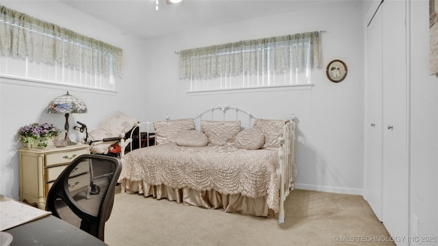 bedroom featuring light carpet and a closet