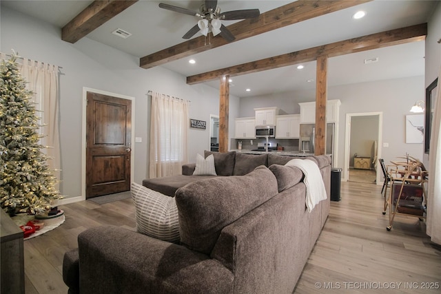 living room with ceiling fan, plenty of natural light, and light hardwood / wood-style floors