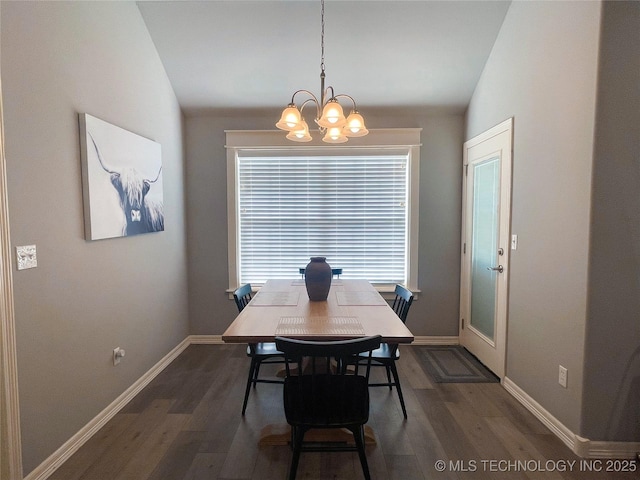 dining room featuring plenty of natural light, dark hardwood / wood-style floors, an inviting chandelier, and vaulted ceiling