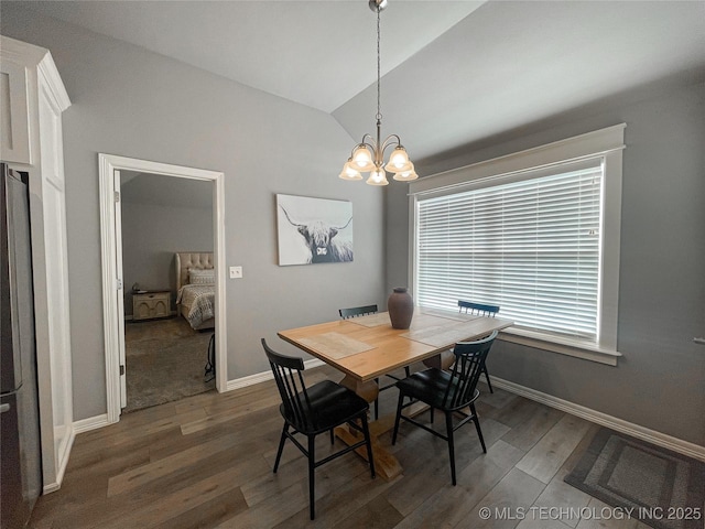 dining area with dark hardwood / wood-style floors, lofted ceiling, and an inviting chandelier