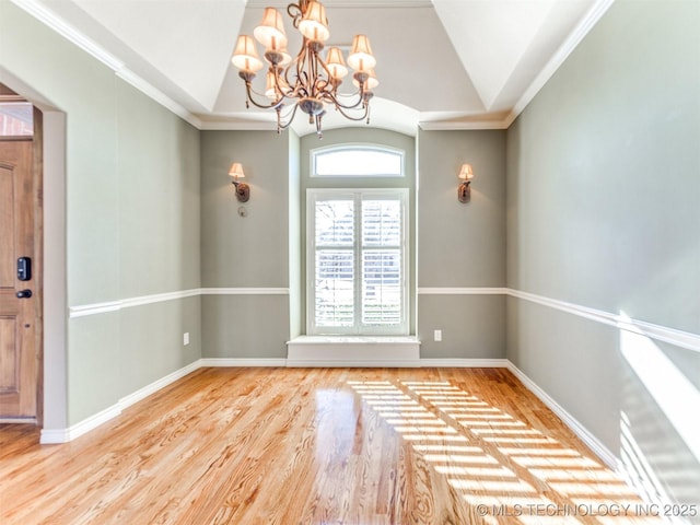 interior space with crown molding, a chandelier, vaulted ceiling, and hardwood / wood-style flooring