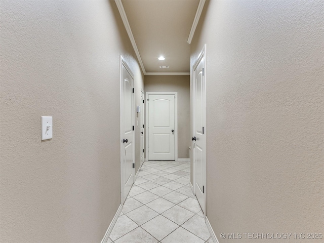 hall featuring light tile patterned flooring and ornamental molding