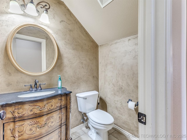 bathroom with tile patterned floors, vanity, lofted ceiling, and toilet