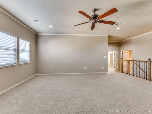 spare room featuring ceiling fan, light colored carpet, and ornamental molding