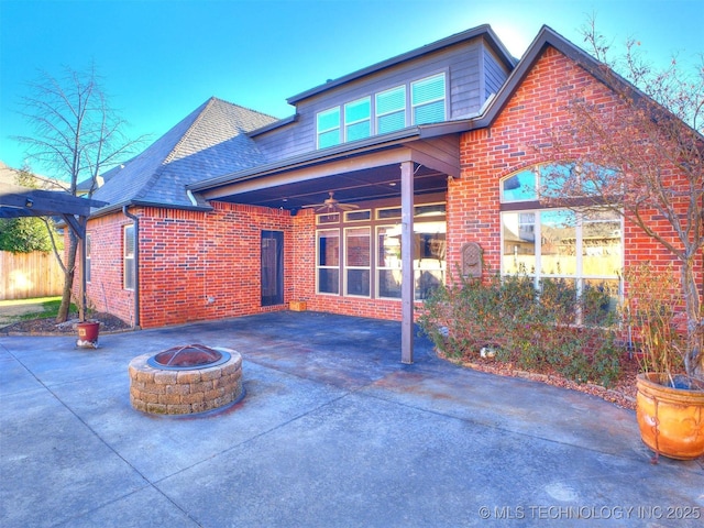 back of property featuring a fire pit, ceiling fan, and a patio area