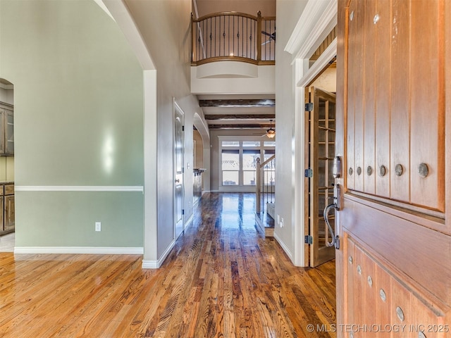 foyer featuring beam ceiling, french doors, ceiling fan, and dark wood-type flooring