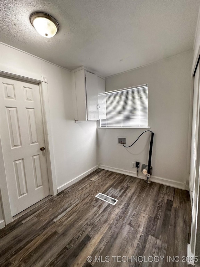 laundry area with cabinets, dark hardwood / wood-style floors, a textured ceiling, and washer hookup