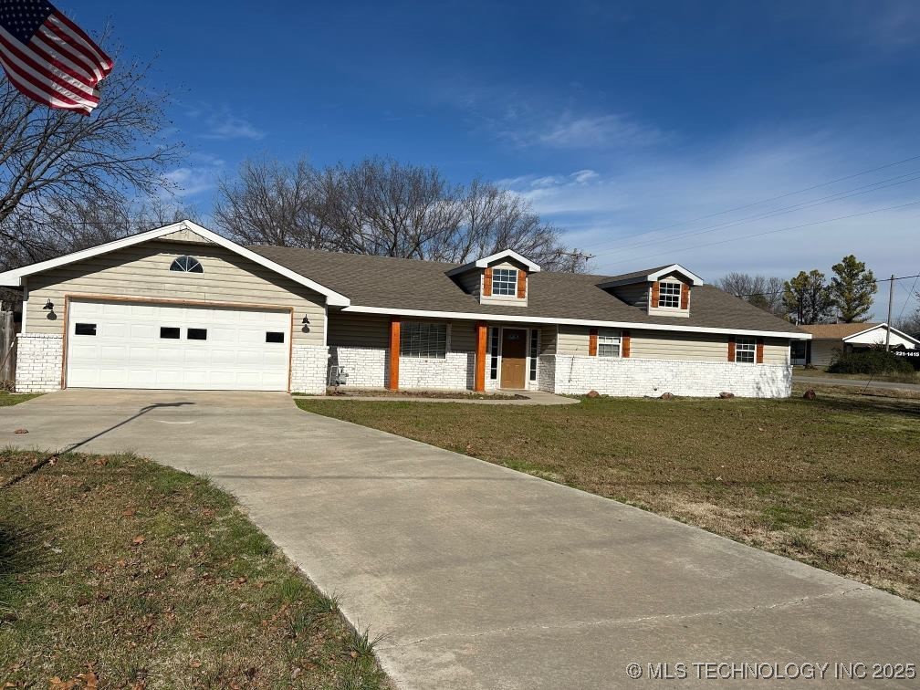 view of front of house featuring a garage, covered porch, and a front yard