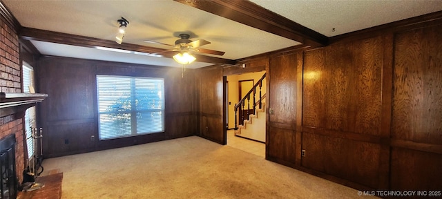 living room with wood walls, a fireplace, ceiling fan, and beamed ceiling