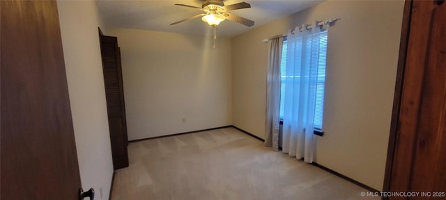 carpeted spare room featuring ceiling fan