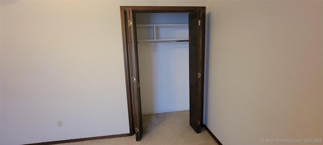 unfurnished bedroom featuring light colored carpet and a closet