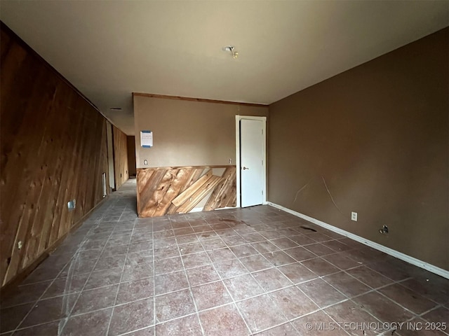 unfurnished room with wood walls