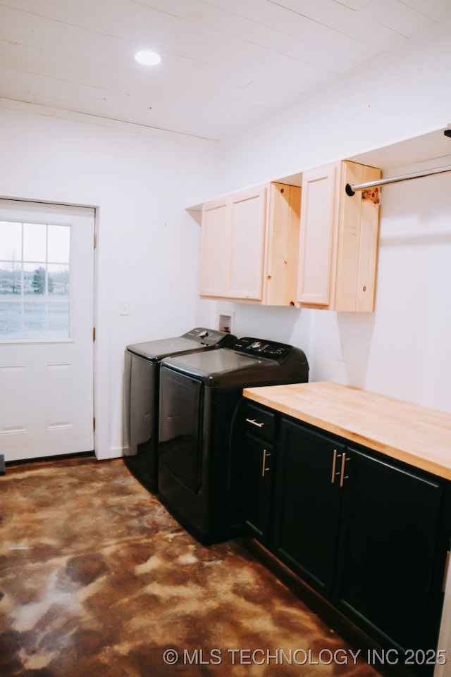 clothes washing area with washer and clothes dryer and cabinets