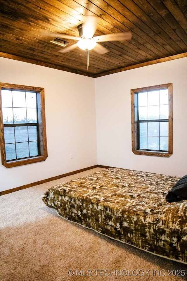 unfurnished bedroom featuring carpet flooring, ceiling fan, and wooden ceiling