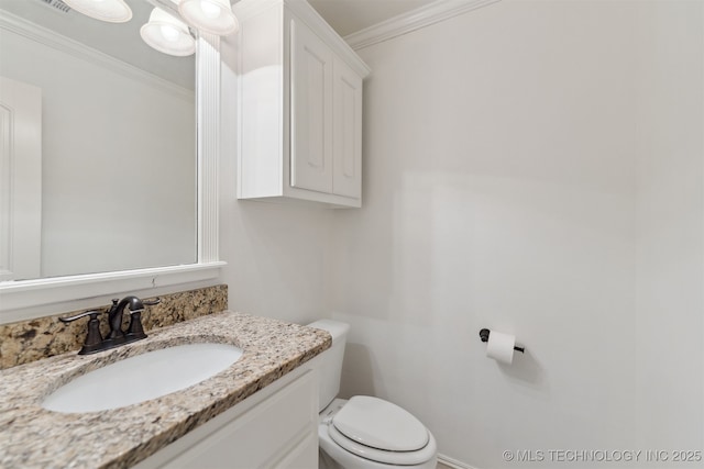 bathroom with toilet, vanity, and ornamental molding