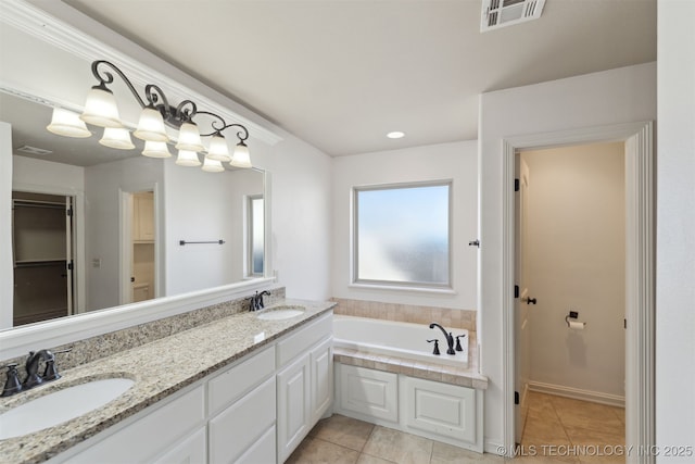 bathroom featuring tile patterned flooring, vanity, and a bathtub