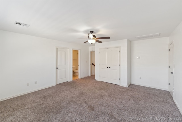 unfurnished bedroom with carpet flooring, ceiling fan, and ensuite bath