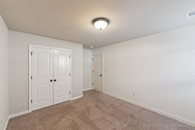 unfurnished bedroom with carpet flooring and a closet