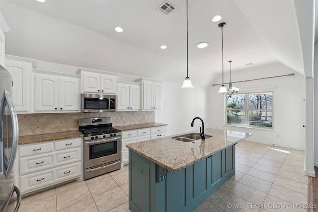 kitchen with hanging light fixtures, sink, light stone countertops, appliances with stainless steel finishes, and white cabinetry