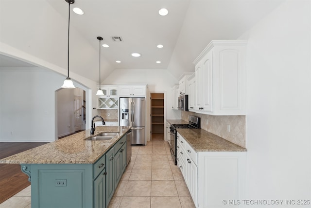 kitchen with lofted ceiling, a center island with sink, sink, white cabinetry, and stainless steel appliances