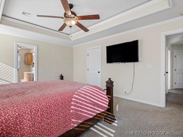 bedroom featuring a raised ceiling, ceiling fan, crown molding, and ensuite bathroom