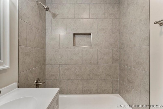 bathroom featuring vanity and tiled shower / bath