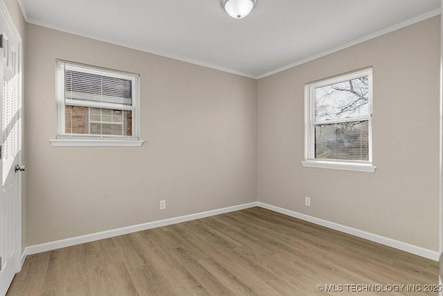 empty room with light hardwood / wood-style flooring and crown molding