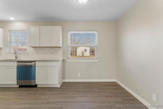 kitchen with sink, stainless steel dishwasher, decorative backsplash, light wood-type flooring, and white cabinetry