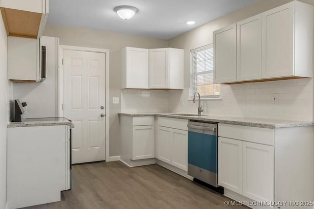 kitchen with white cabinets, sink, light hardwood / wood-style flooring, stainless steel dishwasher, and tasteful backsplash