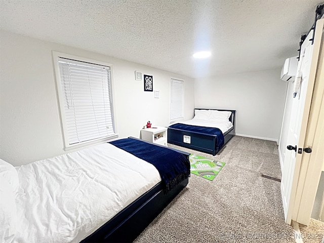 carpeted bedroom featuring an AC wall unit and a textured ceiling