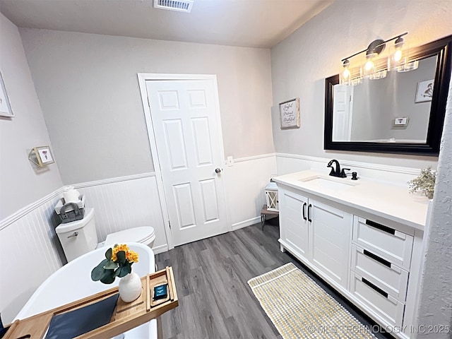 bathroom with vanity, hardwood / wood-style flooring, and toilet