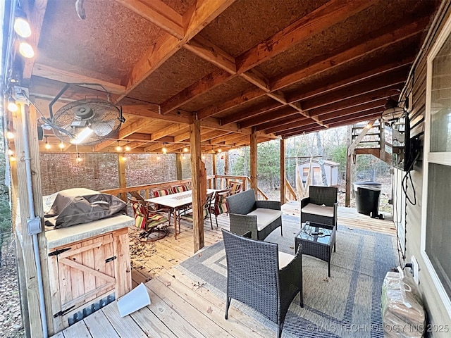 wooden terrace featuring grilling area and a storage unit