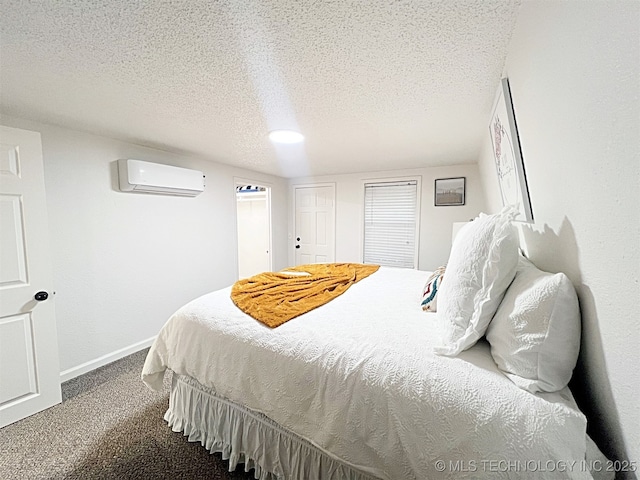 bedroom featuring a wall unit AC, carpet, and a textured ceiling