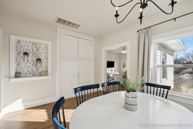 dining room featuring ceiling fan with notable chandelier and light hardwood / wood-style flooring