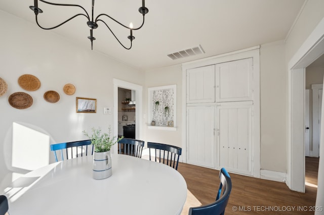 dining space featuring dark hardwood / wood-style flooring and a chandelier